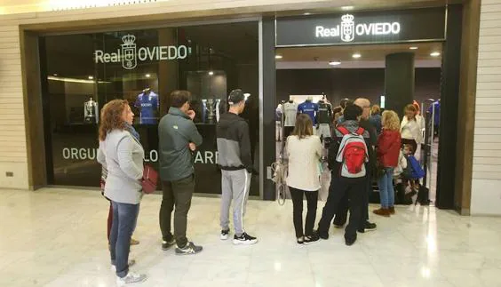 Aficiionados del Real Oviedo guardan cola en la tienda del club en el centro comercial Modoo.