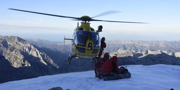 El helicóptero de los bomberos del SEPA vuela a escasos metros del lugar donde atienden a la montañera herida en Cabrales. 