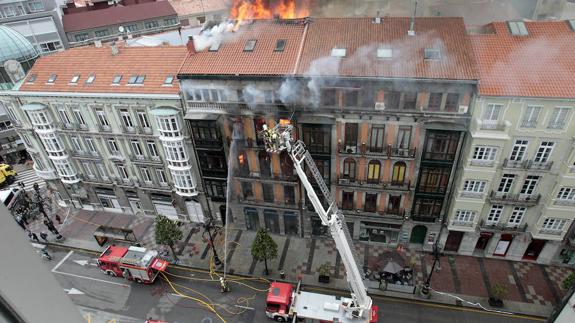 Eloy Palacio y JuanCarlos Fernández, ‘Cuni’, subidos a la autoescalera el día que el fuego colapsó el edificio de Uría, 58 y puso a la ciudad de Oviedo en jaque.