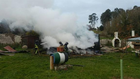 Los bomberos sofocan el fuego en en la vivienda. 