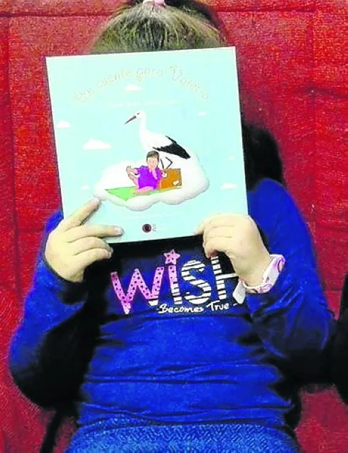 Una niña con su libro 'Un cuento para Valeria'. 