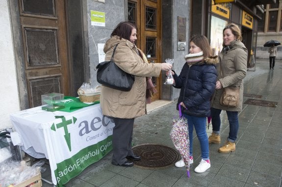 La voluntaria Paula Pérez reparte manzanas en la plaza del Parchís, en Gijón. 