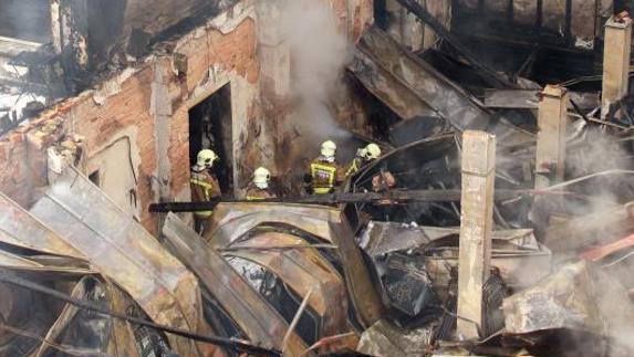 Efectivos de bomberos durante las tareas de extinción del incendio registrado esta mañana en un bazar de Oviedo.