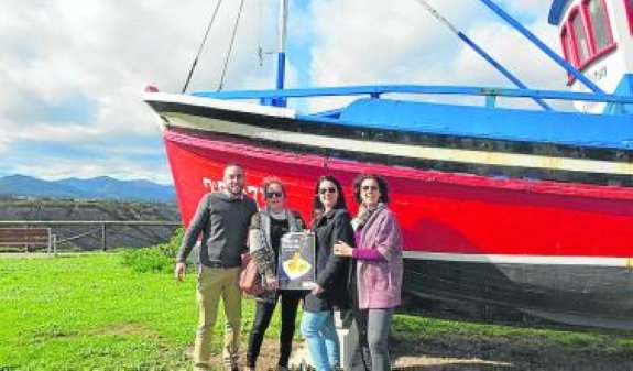 Socios de Oviñana Turismo y Ocio, con el cartel del concurso. :: D. S. F.