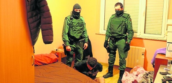 Agentes de la Guardia Civil, en el registro realizado a una vivienda, con uno de los detenidos. 