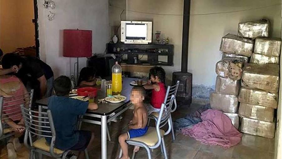 Los niños, comiendo junto a los fardos de droga