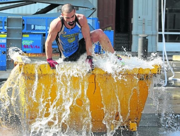 Uno de los atletas sale en solitario de un contenedor lleno de agua fría. 