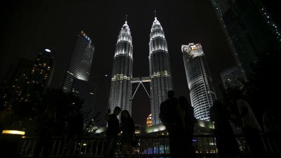 Varias personas toman fotografías de las Torres Gemelas de Petronas momentos antes del apagón simbólico con motivo de la 'Hora del Planeta' en Kuala Lumpur (Malasia).
