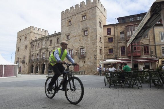 Un ciclista circula delante del Palacio de Revillagigedo, que inaugurará la muestra en julio. 