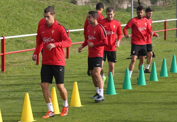 Los jugadores del Sporting B sortean una serie de conos durante un entrenamiento. 