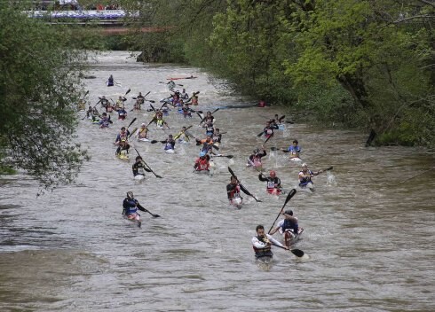 Varios piragüistas compiten en la pasada edición del Descenso del Piloña. Este año el río baja con mucha menos agua. 