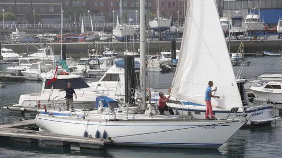La tripulación del ‘Wanted’ trabaja en la puesta a punto del velero en el Puerto Deportivo de Gijón. 