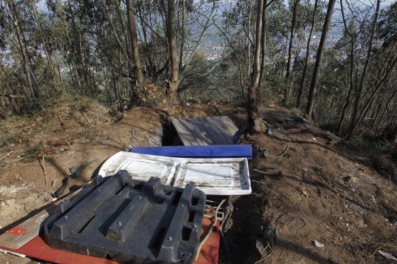 El zulo al que se accede a través de un sendero ubicado junto a las antenas de televisión del aparcamiento del Naranco y al fondo la ciudad de Oviedo. 