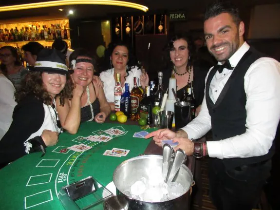Pilar Álvarez, Pili Fernández, Suni Rodríguez y Elisa Tuero jugando sus fichas con el barman Juanjo en su barra-casino.