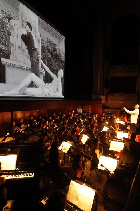 Mariano Rivas dirige a la orquesta mientras se proyecta la película. 