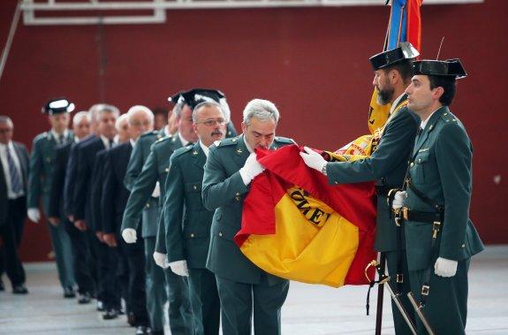 Guardias civiles que pasan a la situación de retirados, besando la bandera, en Oviedo. 