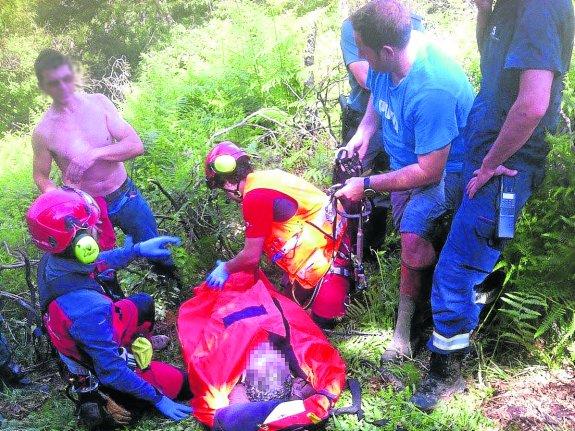 El guarda es atendido en los montes de Següencu antes de ser izado en camilla al helicóptero. 