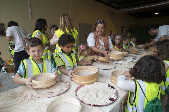 Escolares del colegio Miguel Hernández 'piñeran' la harina en el recinto ferial. 