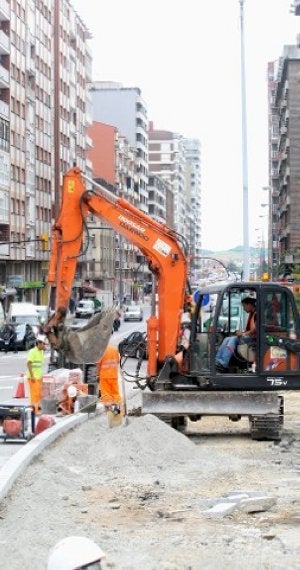 Una máquina trabaja en la reforma de la acera de la avenida a la altura del parque de Cocheras. ::
PIÑA