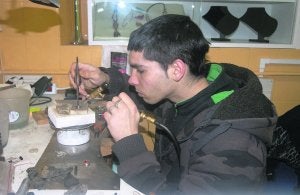 El joven Ángel González, trabajando en el taller de su tienda de la plaza de abastos . ::
L. I. A.