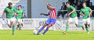 El rojiblanco Adama controla el esférico rodeado de jugadores del Coruxo en el partido disputado ayer en Vigo. ::
MARTA BREA