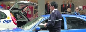 Un agente sostiene el boletín de sanciones para multar a un conductor por circular por la calle Uría. ::                             JESÚS DÍAZ