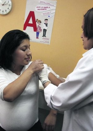 Una inmigrante embarazada recibe una vacuna contra la gripe en un centro de salud. ::                             C. RODRÍGUEZ