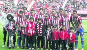 La pequeña Elena, a la izquierda, posa con la alineación del Sporting junto a otros niños minutos antes del inicio del partido en El Molinón. ::
LUIS SEVILLA