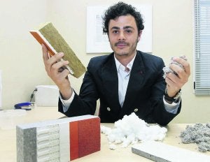 Roberto Cavia exhibe materiales con los que reforzar el aislamiento de un inmueble; en sus manos hay una muestra de celulosa y lana de vidrio. Sobre la mesa, fachada ventilada, lana de roca y 'sate' . ::                             J. P.