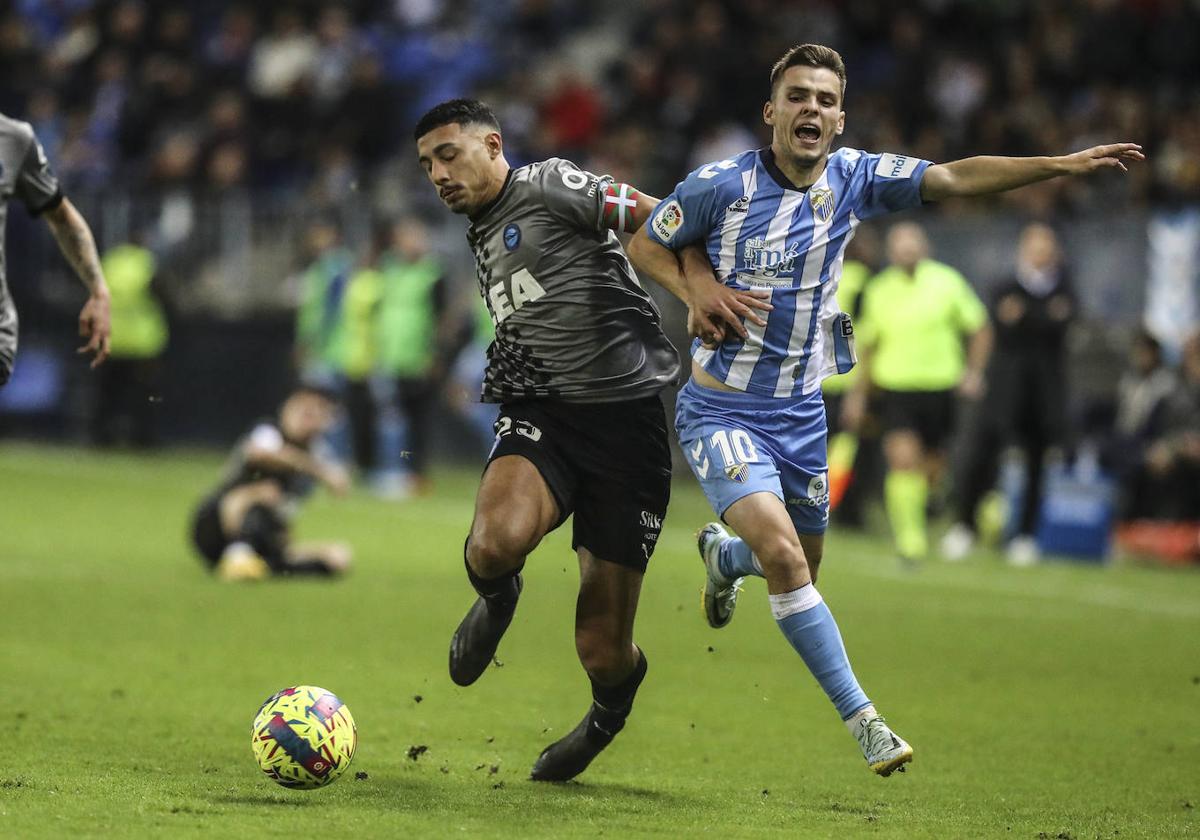 Carlos Benavídez pelea con un jugador del Málaga.