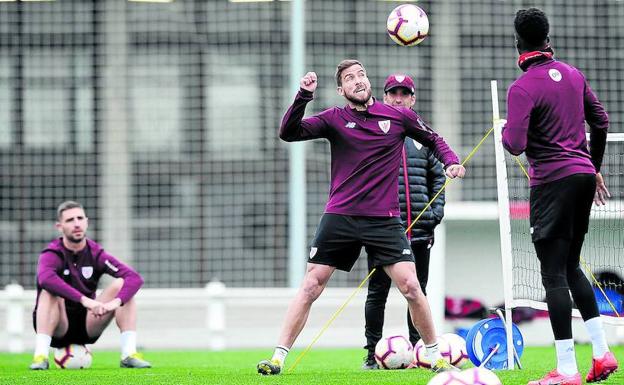 Iñigo Martínez, que mañana será baja por tarjetas, se entrena en Lezamaobservado por Yeray.