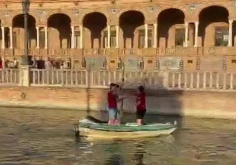 Los aficionados de Osasuna cantan «¿dónde está la gabarra?» mientras pasean en una barca en la plaza España de Sevilla.