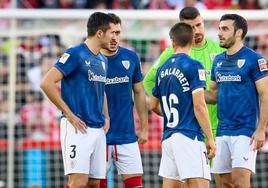 Los jugadores rojiblancos conversan en el césped con el partido suspendido.