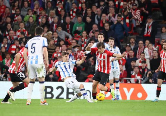 Unai Gómez se lleva el balón ante la presión de la zaga realista.