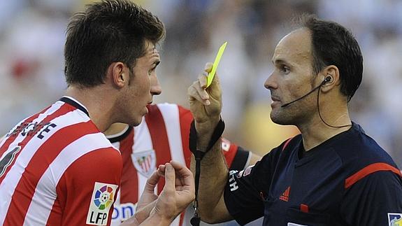 Mateu amonesta a Laporte en el encuentro de la primera jornada en Málaga.