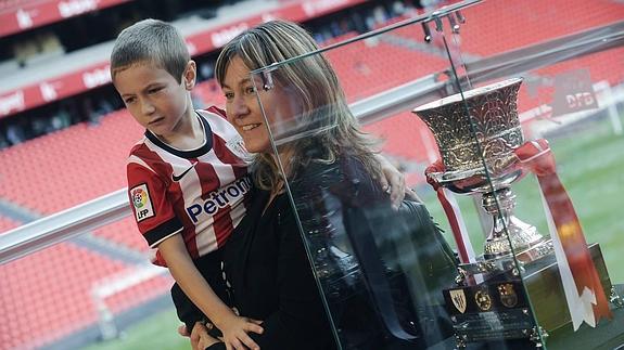 Un niño y su madre se fotografían con la Supercopa en San Mamés.