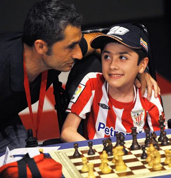 Valverde comenta la jugada con un joven jugador de ajedrez.