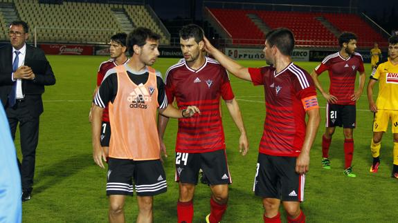 Kijera y Rúper abandonan el rectángulo de juego junto al preparador físico, Héctor Vicente, tras un partido en Anduva.