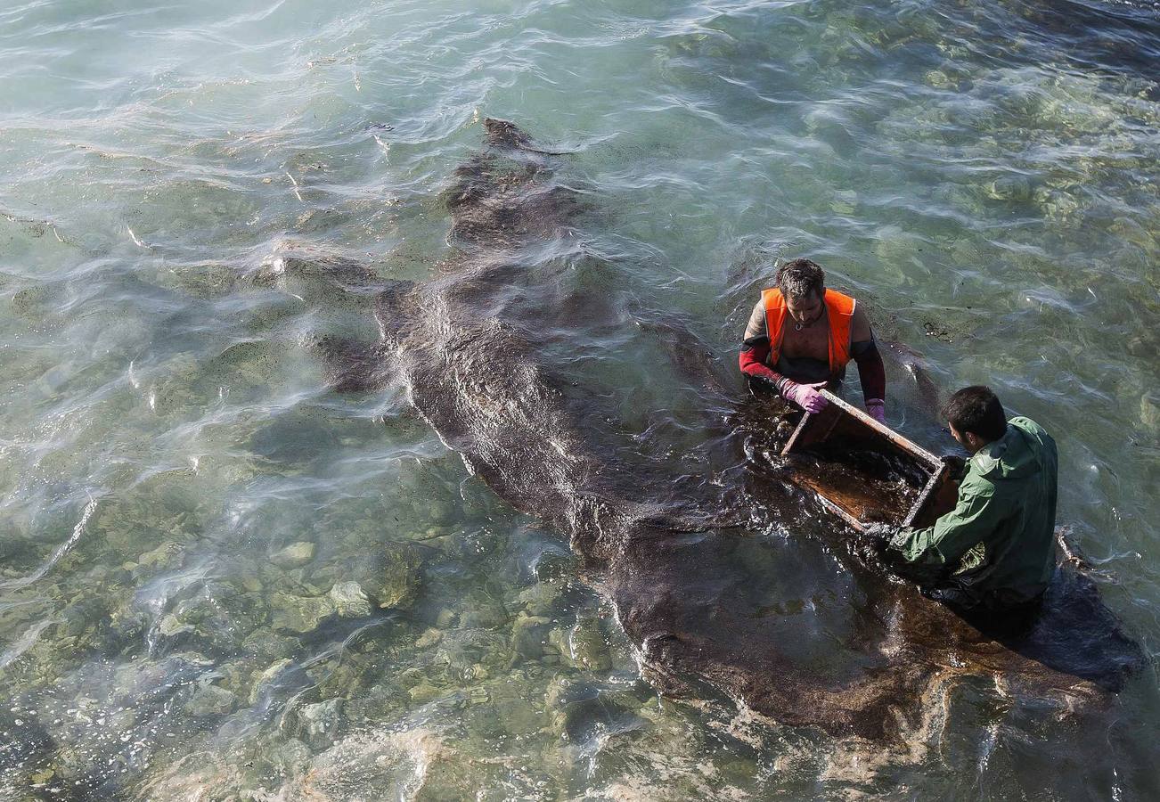 Cientos de personas limpian el vertido en la playa de El Cabrón