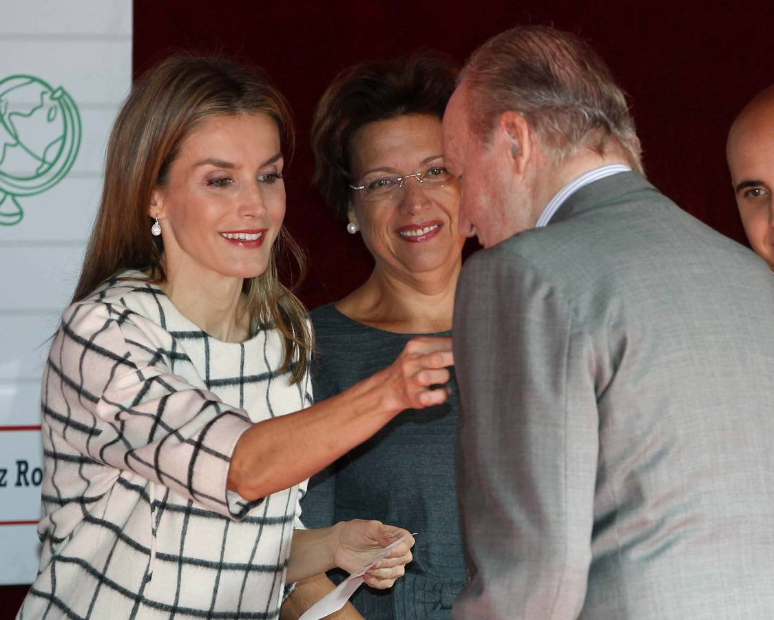 Don Juan Carlos recibe una insignia en la solapa con la emblemática cruz roja de manos de la reina Letizia.