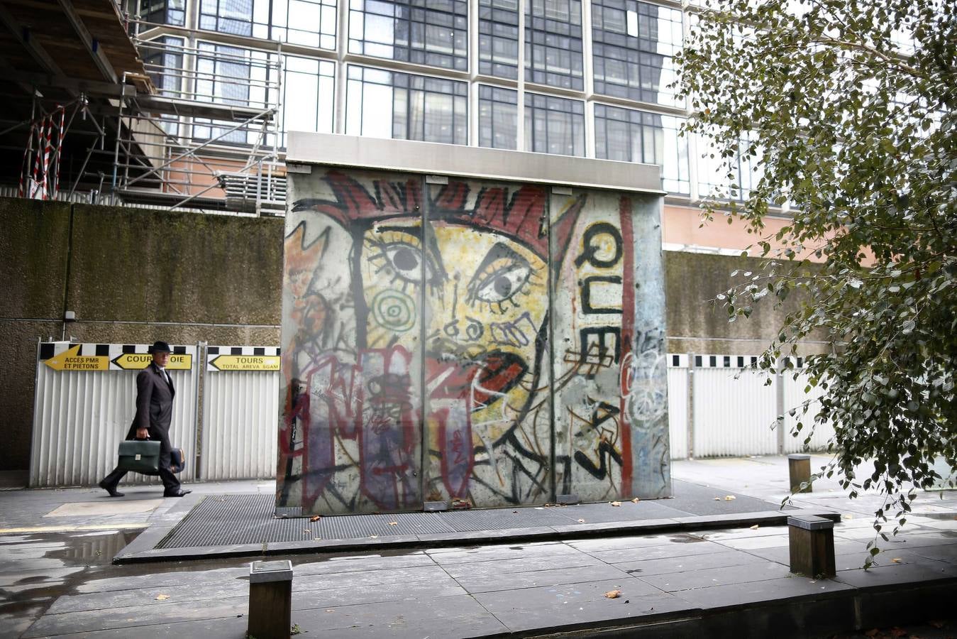Un hombre camina cerca del tramo del Muro de Berlín, en el barrio de La Defense en Courbevoie (Francia)