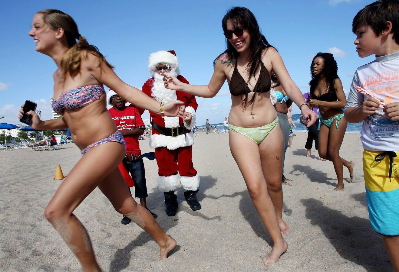 De Laponia a Florida. Tom Tapp, vestido de Santa Claus, reparte caramelos y posa para los fotos de los bañistas el 20 de diciembre de 2013 en Fort Lauderdale, Florida. Tapp lleva 25 años disfrazándose del orondo personaje.