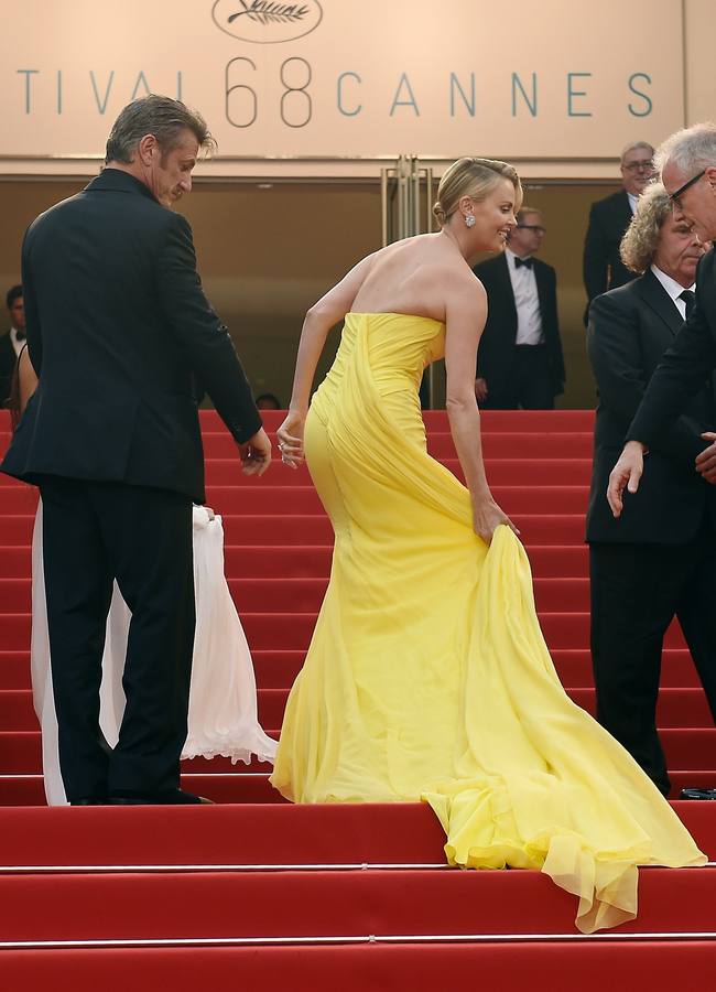 Charlize Theron, acompañada de su pareja, Sean Penn, se recoge la cola de su Dior para subir las escaleras al teatro.