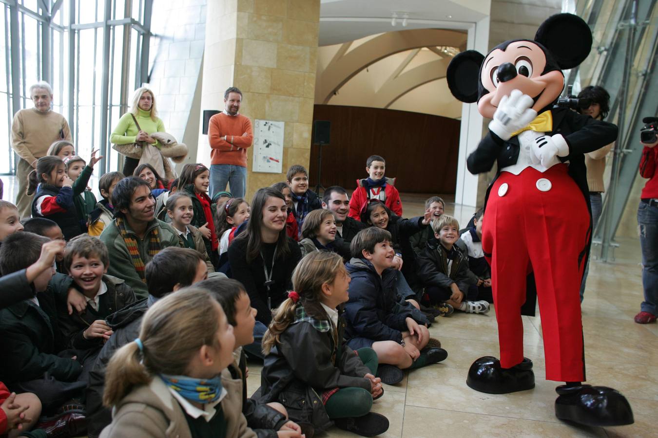 Mickey Mouse entretiene a un grupo de niños en el atrio.