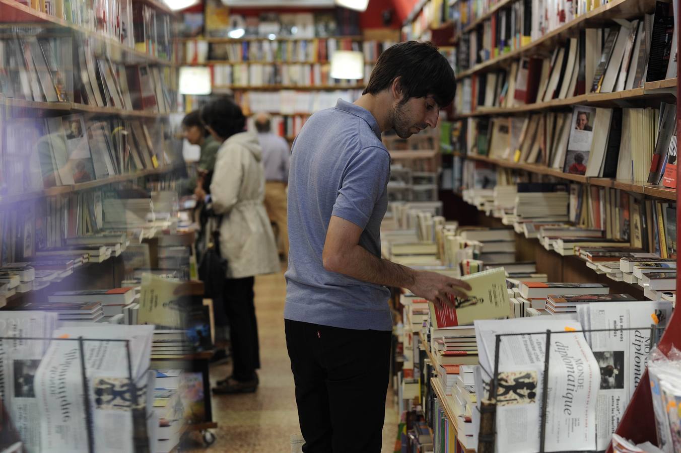 Eduardo Maura, relajadao y mirando libros en una librería.