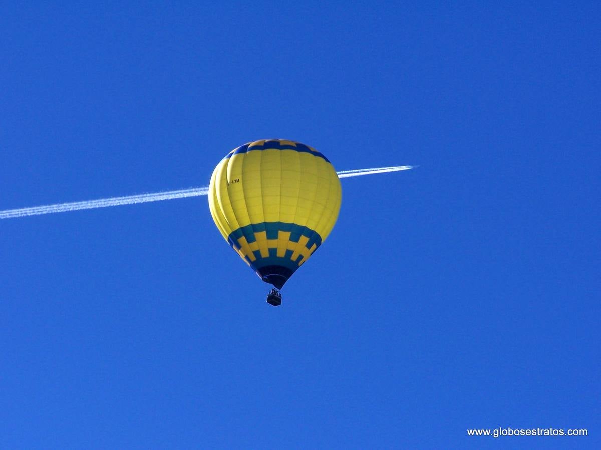 El globo mientras un avión surca el cielo.