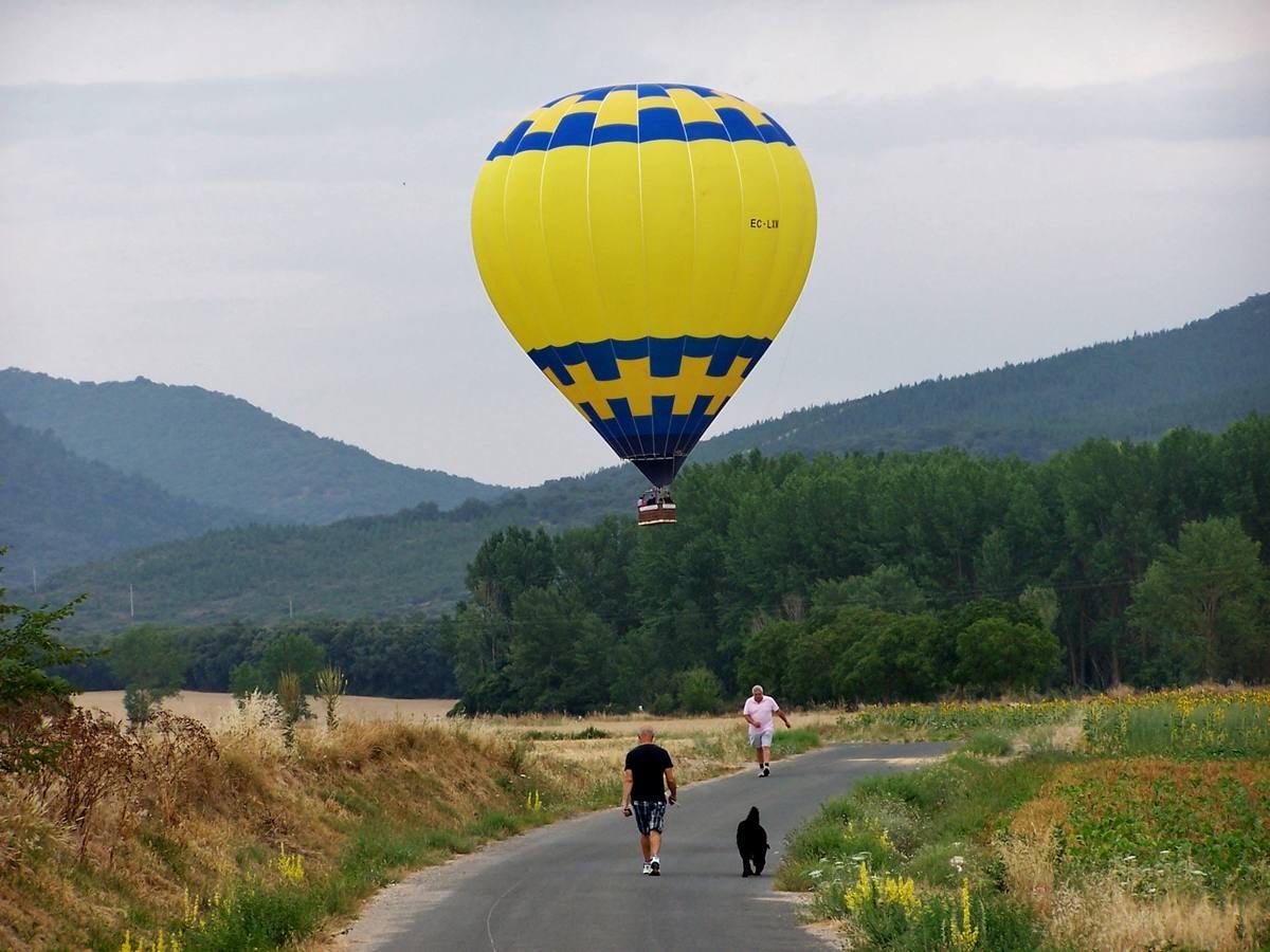 El globo pasa por un camino transitado por paseantes.