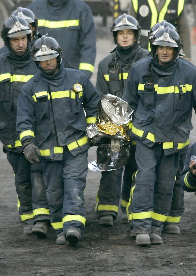 Varios bomberos trasladan el cadáver de Diego Armando Estacio.