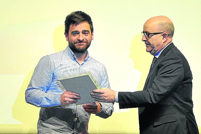 Pablo Berasaluze sostiene el galardón con José Miguel Santamaría, director de EL CORREO.