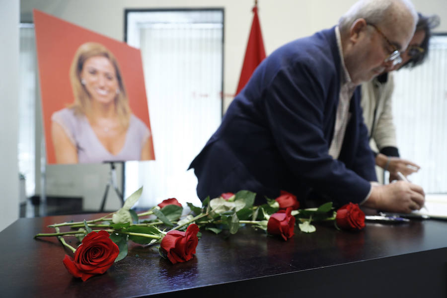 Dos personas firman en el libro de condolencias.